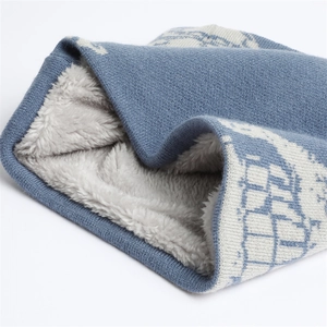 Dettaglio dello scaldacollo invernale blu con fodera in pile e motivo geometrico a maglia