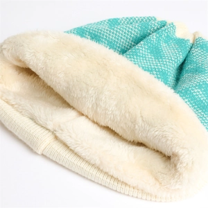Close-up of mint green knit hat featuring thick white fleece lining and ribbed edge