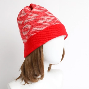 Close-up of red and white jacquard knit beanie with thick ribbed cuff for winter