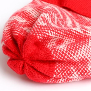 Detailed close-up of red and white knitted winter hat showing fine jacquard weave texture