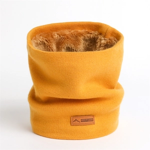 Détail du cache-col en tricot jaune avec doublure en polaire épaisse et étiquette en cuir