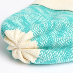 Detailed macro view of mint green knit beanie with star-shaped pleats and wave pattern