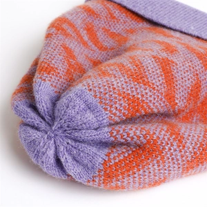 Detailed close-up of purple and orange knitted beanie fabric texture and top stitching
