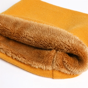 Gros plan d'un tour de cou en tricot jaune avec doublure en peluche brune épaisse