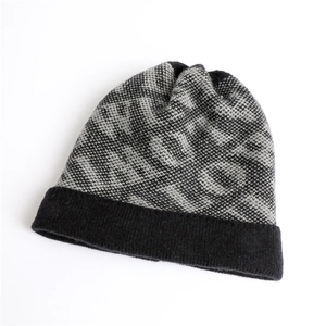 Close-up of gray and black geometric jacquard knit pattern on a warm winter beanie hat