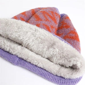 Macro detail of the purple and orange knit winter hat with thick grey fleece lining