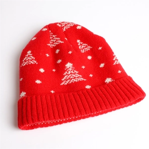 Red Christmas knit beanie with white snowflake and tree patterns on a white background