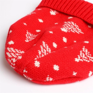 Detail of red knit hat with white Christmas tree pattern and ribbed hem texture