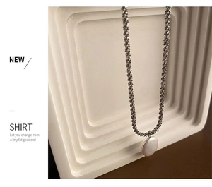 Detailopname van een barokparel hanger aan een zilveren gedraaide metalen ketting