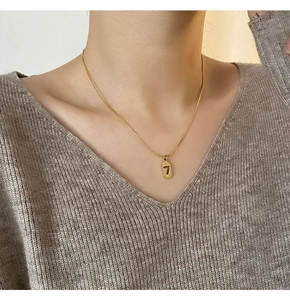 Detail of minimalist gold-plated titanium steel necklace with lucky number 7 pendant