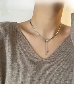 Détail du collier avec pendentif papillon argenté et glands sur un mannequin