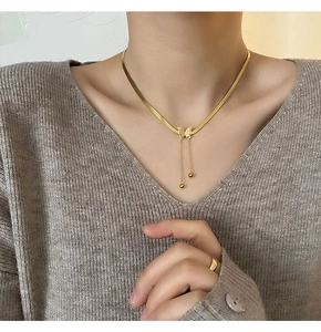 Détail du collier papillon plaqué or 18K avec pampilles élégantes et perles sur la peau