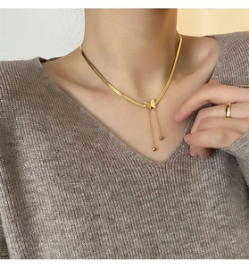 Détail du collier pendentif papillon plaqué or 18K et bague sur le cou d'un mannequin
