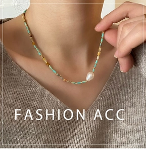 Detail of vintage beaded necklace with baroque pearl and turquoise stones on a model