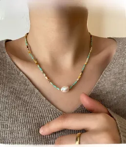 Close-up of baroque pearl and turquoise beaded necklace on model neck and collarbone
