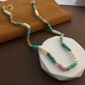 Detail of beaded necklace with blue turquoise, white pearls and gold lobster clasp