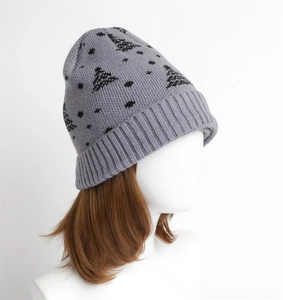Detail of grey knitted beanie with black tree pattern and ribbed cuff for winter warmth