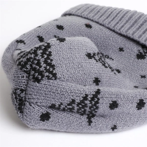 Close-up of grey knitted beanie with black star patterns and thick ribbed texture