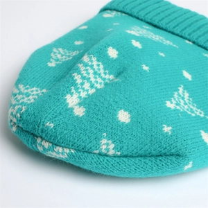 Close-up of knit turquoise beanie with white snowflake and Christmas tree jacquard texture
