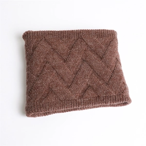 Gros plan détaillé du cache-col en tricot marron avec motif losange et bords côtelés