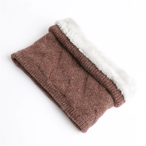 Détail d'un tour de cou en tricot marron avec doublure en polaire blanche et motif diamant