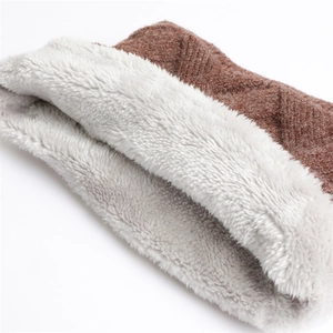 Détail du cache-col montrant le tricot marron à losanges et la doublure en polaire épaisse