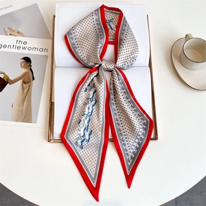 Detail of red and white equestrian silk scarf featuring blue horse pattern and dots