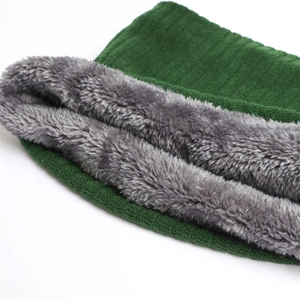 Close-up of thick grey faux fur lining and dark green knitted winter neck warmer fabric