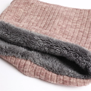 Close-up of winter neck warmer with pink-brown knit exterior and thick gray fleece lining