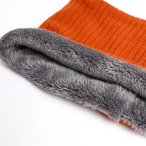 Detail of orange ribbed knit exterior and thick grey fleece lining of a winter neck warmer