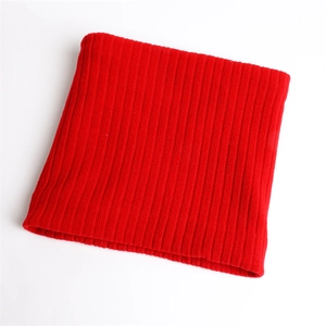 Close-up of thick red knitted neck warmer with ribbed pattern and soft winter texture