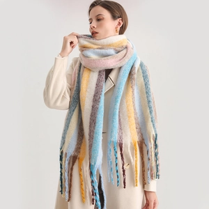 Detail of soft thick knit rainbow striped scarf with long twisted tassels on white coat