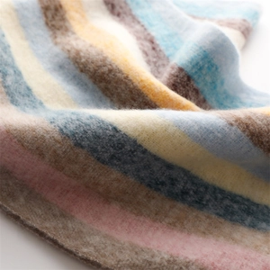 Macro texture of soft rainbow striped cashmere-like knit fabric with cozy fuzzy surface