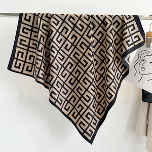 Detail view of the elegant champagne and black geometric pattern printed silk scarf texture