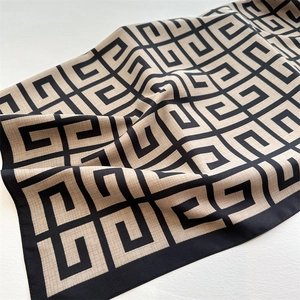 Macro detail of twill silk scarf showing geometric 4G pattern and premium black hem edge