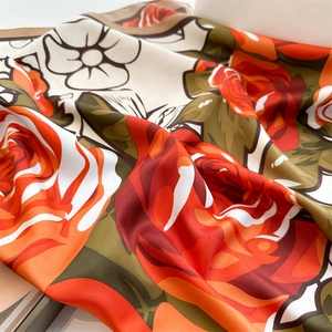 Detailed view of large rose print on silk scarf with smooth satin finish and elegant drape
