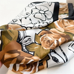 Close-up of rose print silk scarf showing satin texture and floral patterns