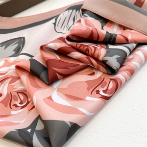 Close-up of elegant rose floral silk scarf showing premium drape and glossy texture