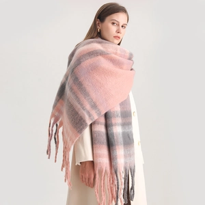Detail of pink and grey plaid cashmere scarf featuring soft thick knit and long tassels
