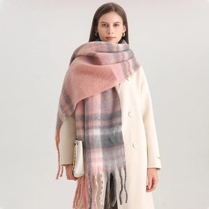 Detail of pink and grey plaid cashmere scarf with long fringe on a cream coat