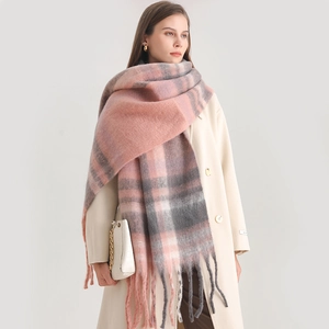 Macro shot of thick winter check scarf featuring soft pink fringe and cashmere-like texture