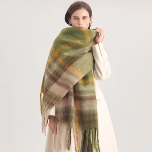 Detail view of thick green and orange plaid cashmere scarf with long tassels