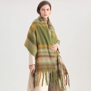 Macro detail of thick winter scarf featuring green and orange plaid pattern with long tassels