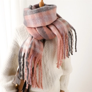 Detail of soft pink and grey checkered scarf with thick cashmere-like fringe texture
