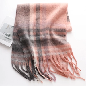 Detailed macro view of pink and grey checkered winter scarf with soft tassel fringe edges