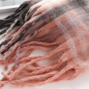 Close-up of soft pink and grey plaid cashmere-like scarf with long fringe detail