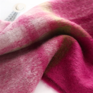 Macro detail of thick faux cashmere scarf featuring pink and green plaid texture