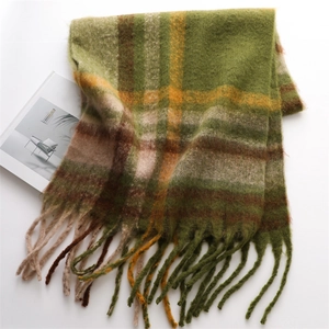 Detail of winter plaid cashmere scarf with green and brown checkered pattern and long tassels