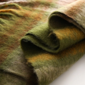Macro detail showing soft brushed texture and classic plaid pattern of the winter scarf