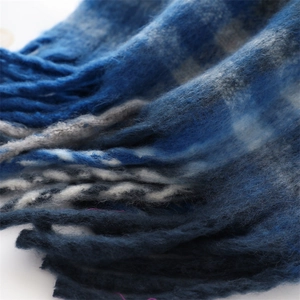 Detail shot of blue and grey plaid scarf showing thick cashmere-like fuzzy texture